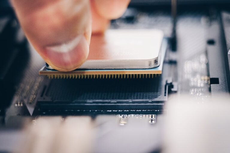 Hand placing an AMD chip on a motherboard, showcasing advanced semiconductor technology