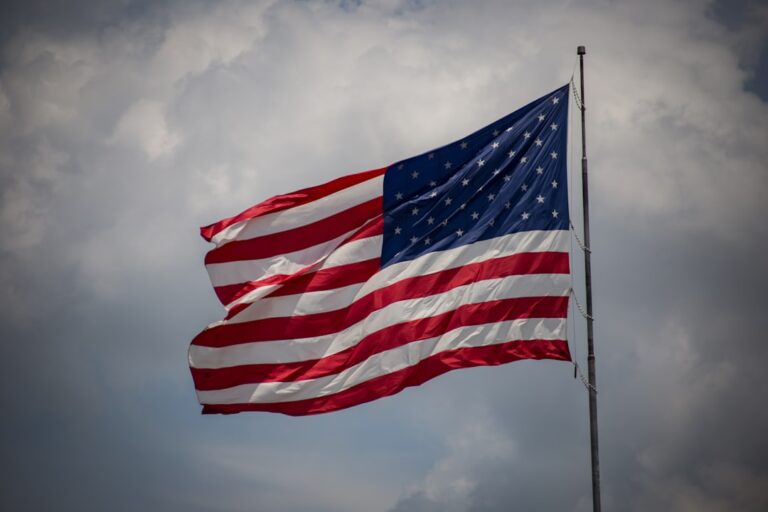 American flag waving under a cloudy sky