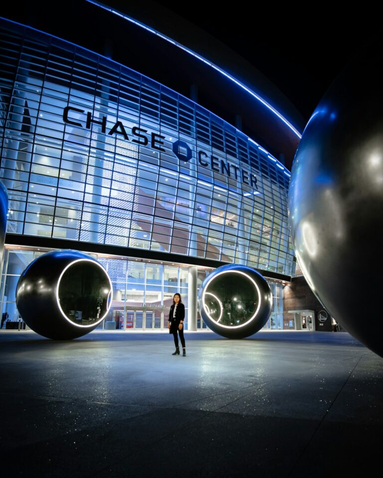 A person standing in front of the illuminated JPMorgan Chase Center at night