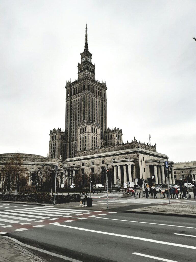 Image depicting a grand, tall building with intricate design, surrounded by city streets and crosswalks.