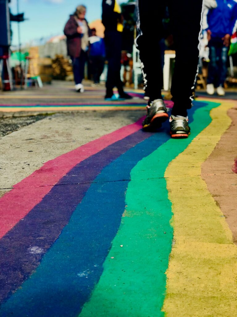Close-up of multicolored stripes on a pedestrian walkway with people walking