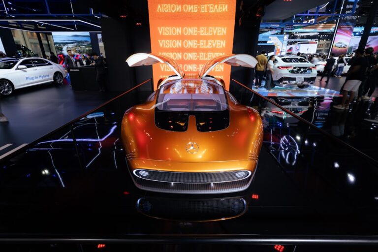 New electric vehicle concept car with gullwing doors displayed at an auto show, highlighting innovative designs in the automotive industry.