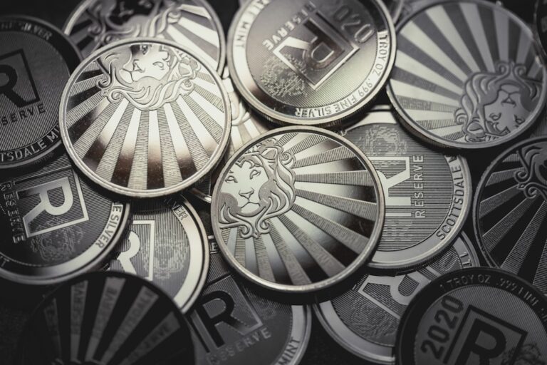 Close-up view of silver coins stacked together, reflecting light and showcasing intricate designs.