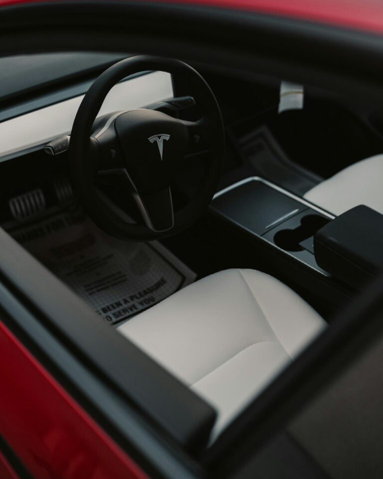 Interior view of a Tesla car featuring a sleek steering wheel and modern design