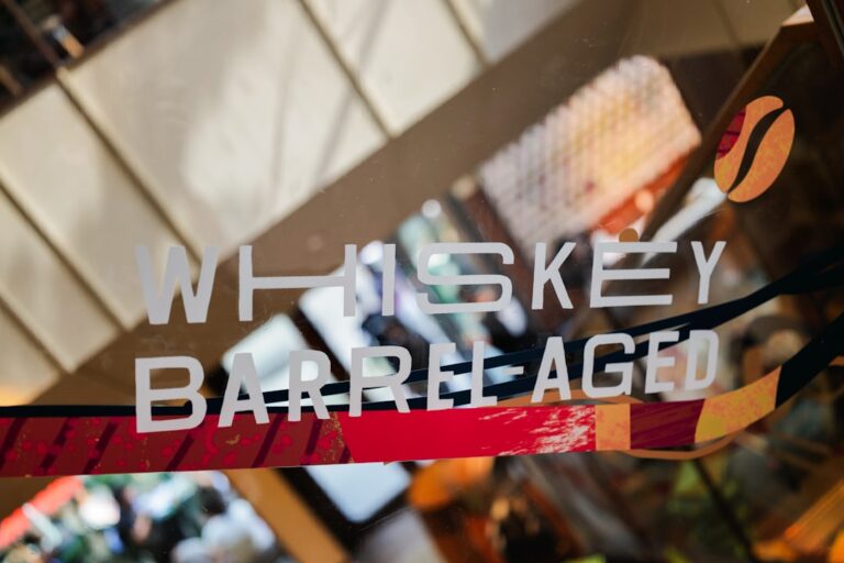 Whiskey barrel-aged sign seen through a glass with blurred background
