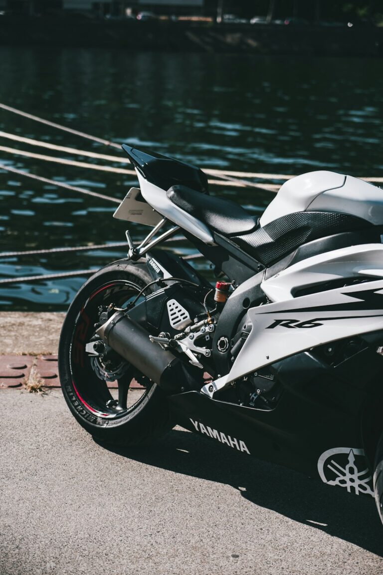A Yamaha R6 motorcycle parked beside a river, showcasing its sleek design and advanced engineering.