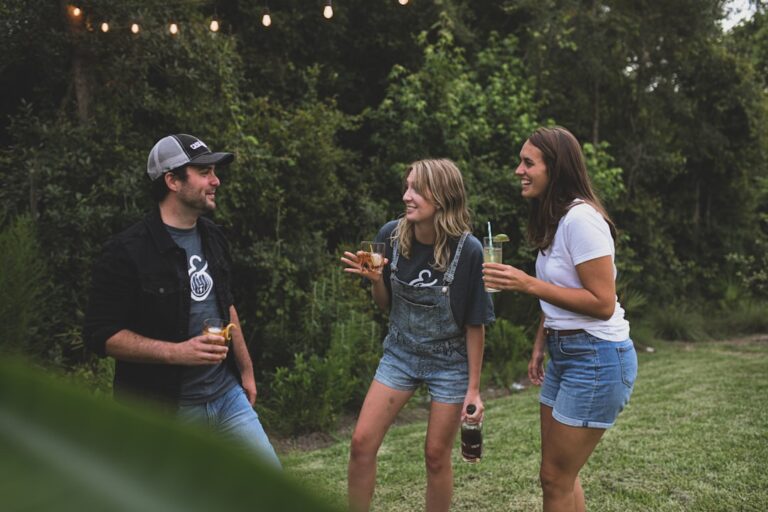 Three young adults happily conversing and drinking outdoors, reflecting a new era of political engagement in the UK.