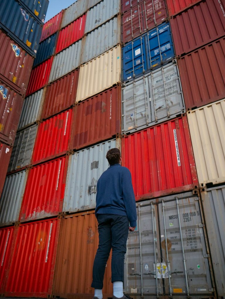 Man looking at stacked shipping containers representing China's economic challenges