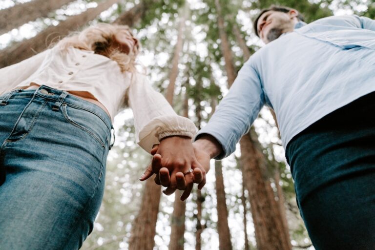 Low angle view of a couple holding hands while standing in a forest