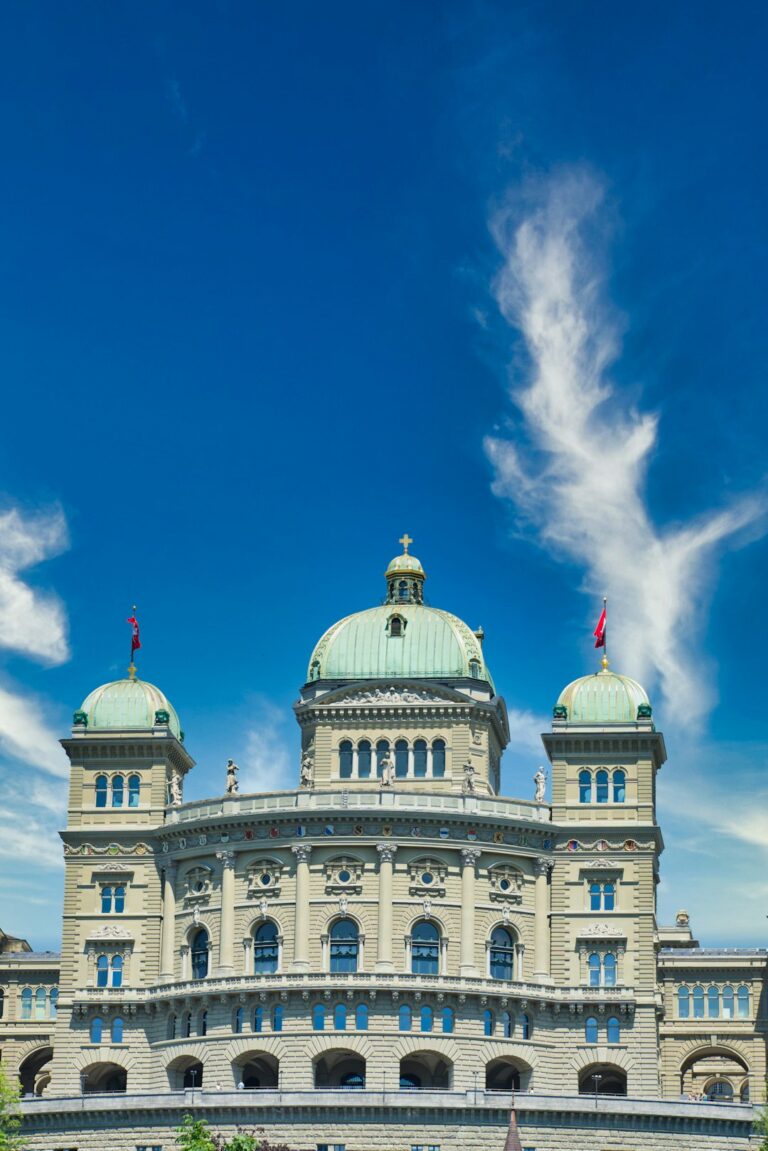 The exterior of the Federal Reserve building with three domed towers under a clear blue sky.