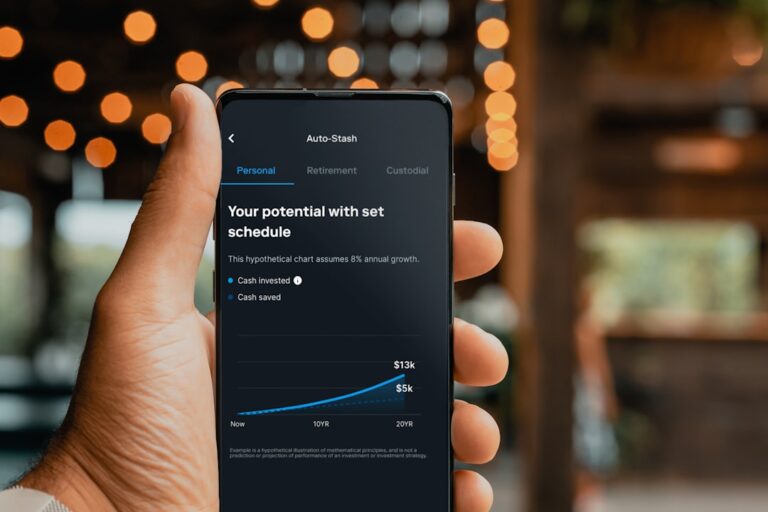 Close-up of a person holding a smartphone displaying an investment growth chart