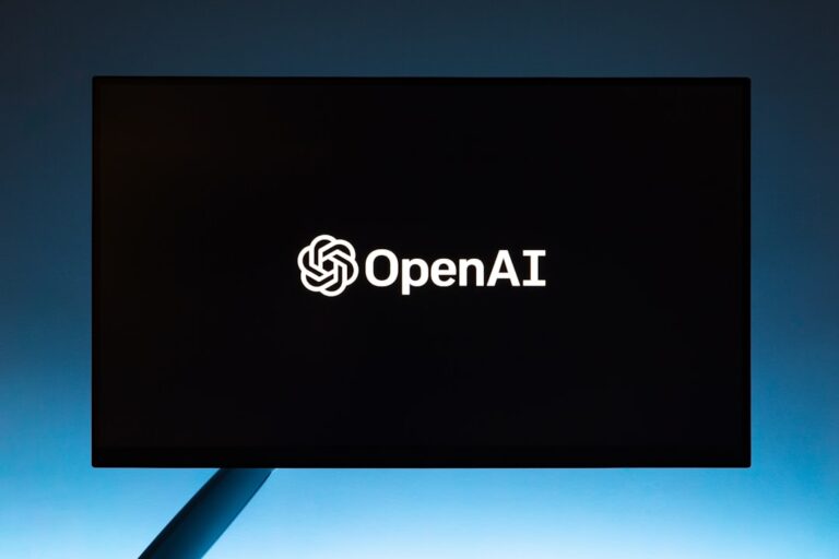 Monitor displaying OpenAI logo against a dark background, highlighting the impact of AI on job markets