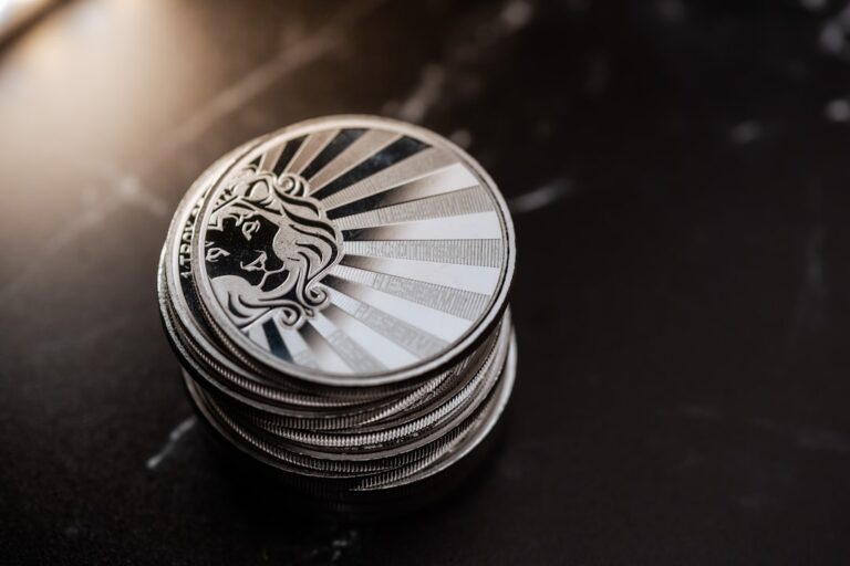 Close-up of a stack of silver coins on a dark surface